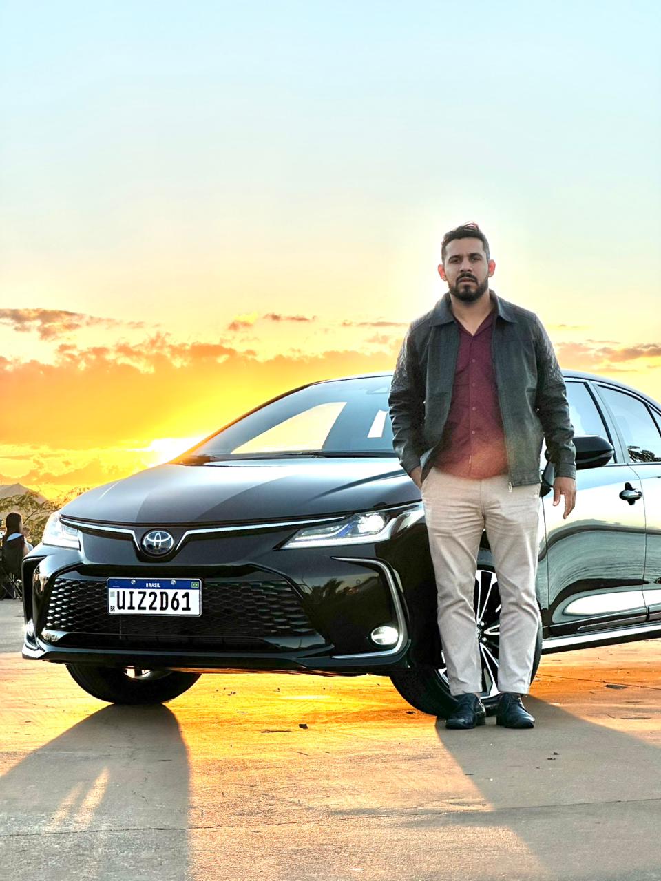 Motorista executivo com Toyota Corolla ao pôr do sol